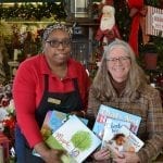 Jill Williams, manager of Royer’s Flowers & Gifts’ Lancaster, Pennsylvania, (left) offers Renee Christiansen, youth services manager of the Library System of Lancaster County, children’s books customers donated during the company’s “Bouquets for Books” program.