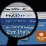 Photo of HealthCare.gov homepage on a monitor screen through a magnifying glass