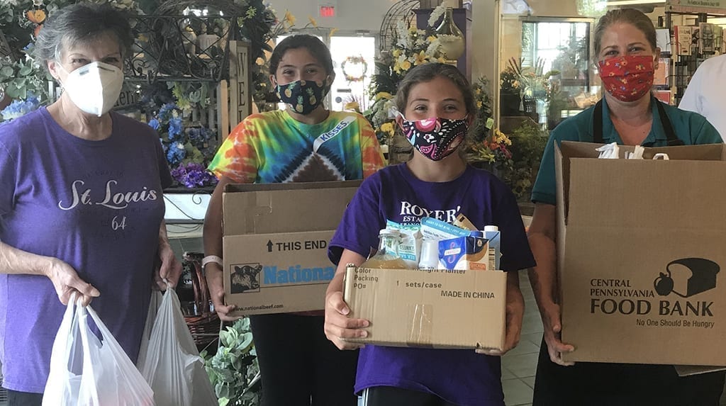 people holding food for donation to food banks